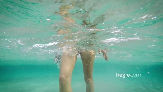 Молоденькая нудистка купается обнаженной в море и прогуливается по пляжу